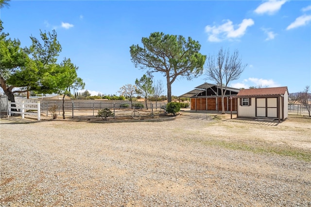 view of yard featuring an exterior structure, an outdoor structure, and a rural view