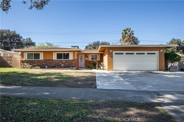 ranch-style home with a garage, fence, concrete driveway, a gate, and stucco siding