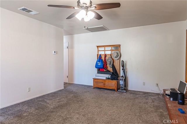 carpeted spare room with a ceiling fan, visible vents, and baseboards