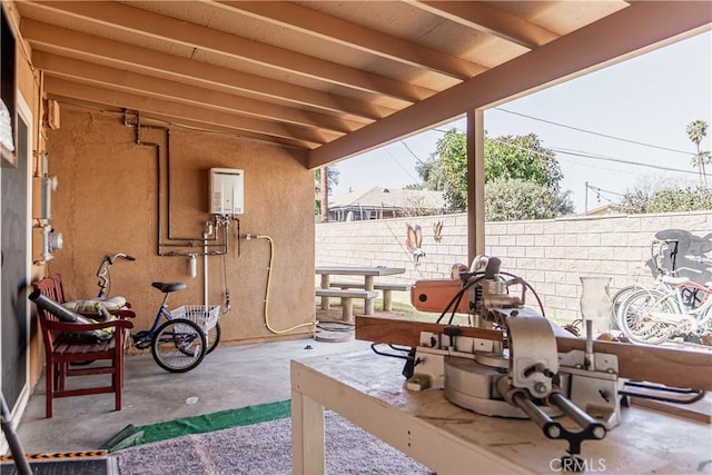 view of patio / terrace featuring water heater and fence