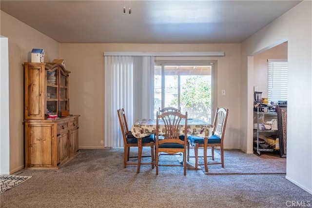 dining space with carpet and baseboards