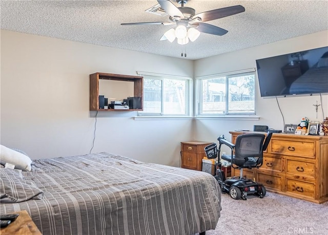 carpeted bedroom featuring a ceiling fan and a textured ceiling