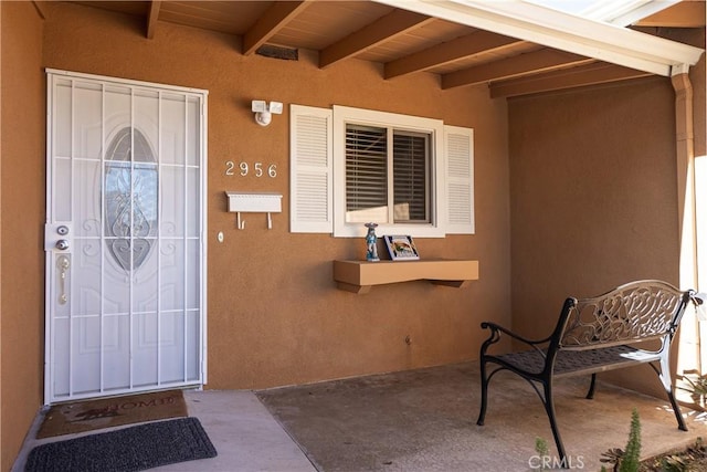 property entrance with stucco siding