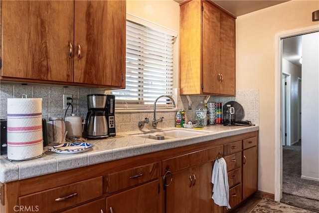 kitchen with brown cabinets, backsplash, and a sink