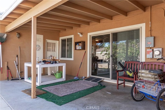 entrance to property with a patio and stucco siding