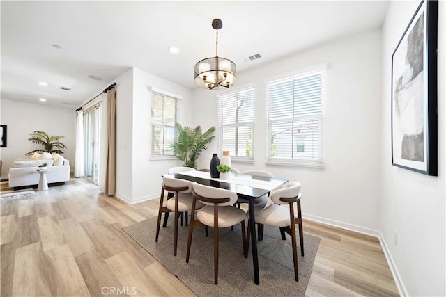 dining space featuring light wood-style floors, a chandelier, baseboards, and recessed lighting