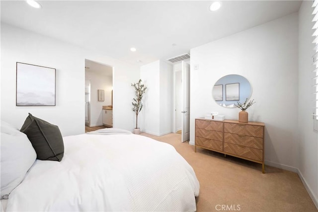 bedroom with light carpet, recessed lighting, baseboards, and ensuite bath