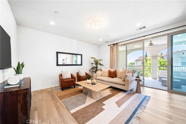 living room featuring light wood finished floors, recessed lighting, and baseboards