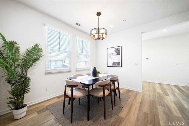 dining area featuring a chandelier, light wood-type flooring, baseboards, and recessed lighting