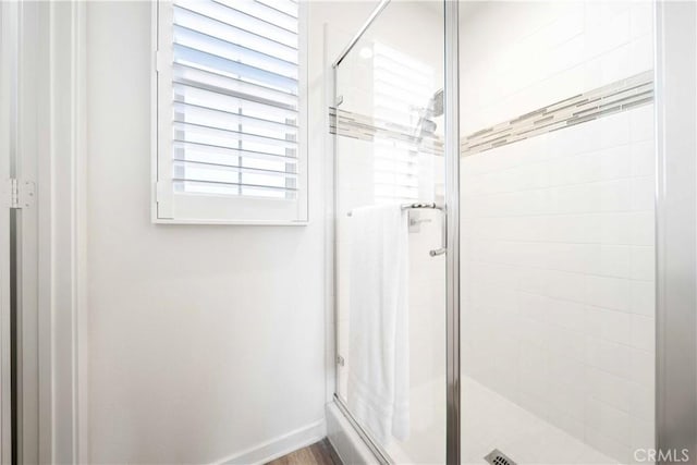full bath with a stall shower and baseboards