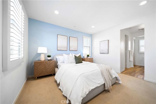bedroom with light carpet, multiple windows, baseboards, and recessed lighting