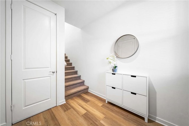 stairs with wood finished floors and baseboards