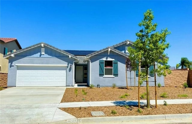 ranch-style home with solar panels, a tiled roof, stucco siding, a garage, and driveway