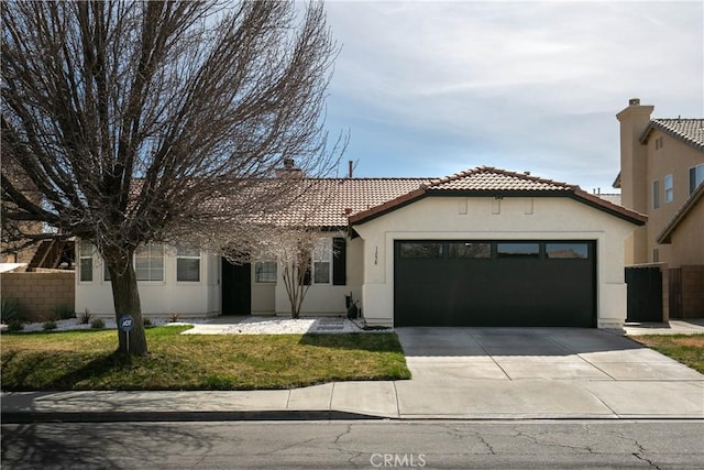 view of front of home featuring an attached garage, fence, concrete driveway, stucco siding, and a front lawn