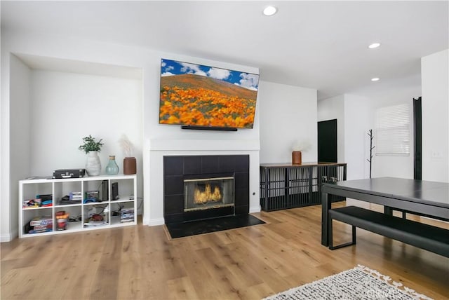 interior space with a fireplace, baseboards, wood finished floors, and recessed lighting