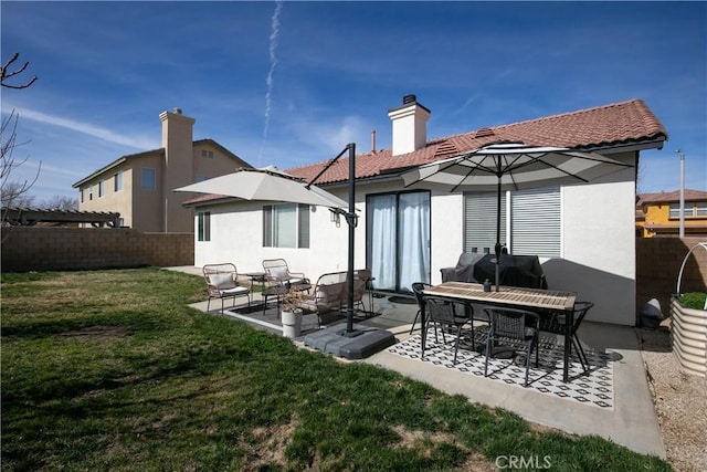 rear view of property featuring a yard, a patio area, and fence