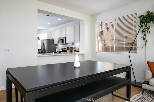 dining space with recessed lighting, visible vents, baseboards, and wood finished floors