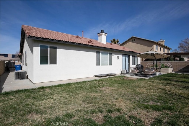 back of property featuring a patio, a tile roof, fence, a lawn, and stucco siding