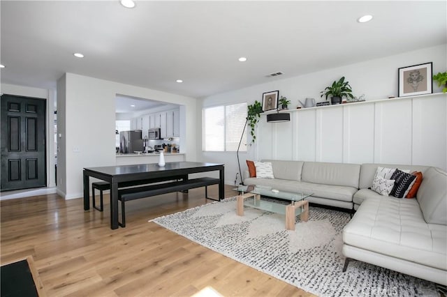 living room featuring recessed lighting, visible vents, light wood-style flooring, and baseboards