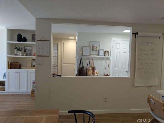 interior space featuring baseboards and wood finished floors