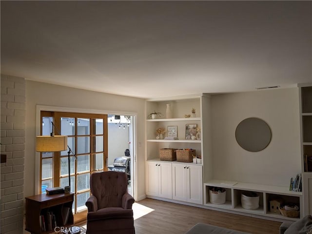 living area with french doors, wood finished floors, and visible vents