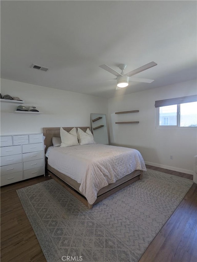 bedroom with visible vents, ceiling fan, baseboards, and wood finished floors