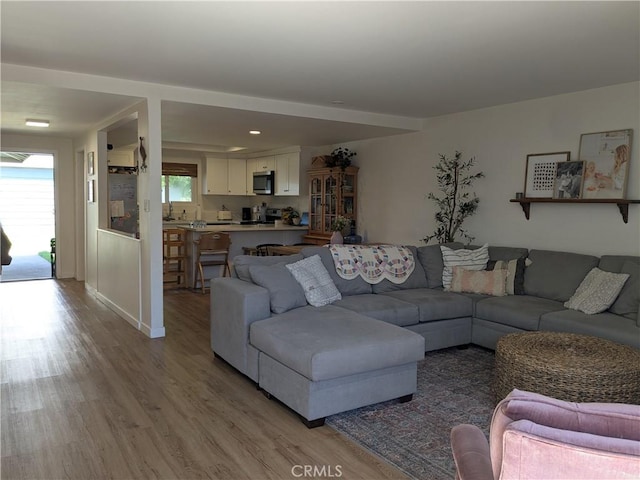 living area with light wood-type flooring and recessed lighting