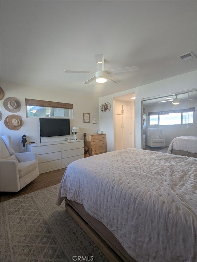 bedroom featuring visible vents, a ceiling fan, and wood finished floors