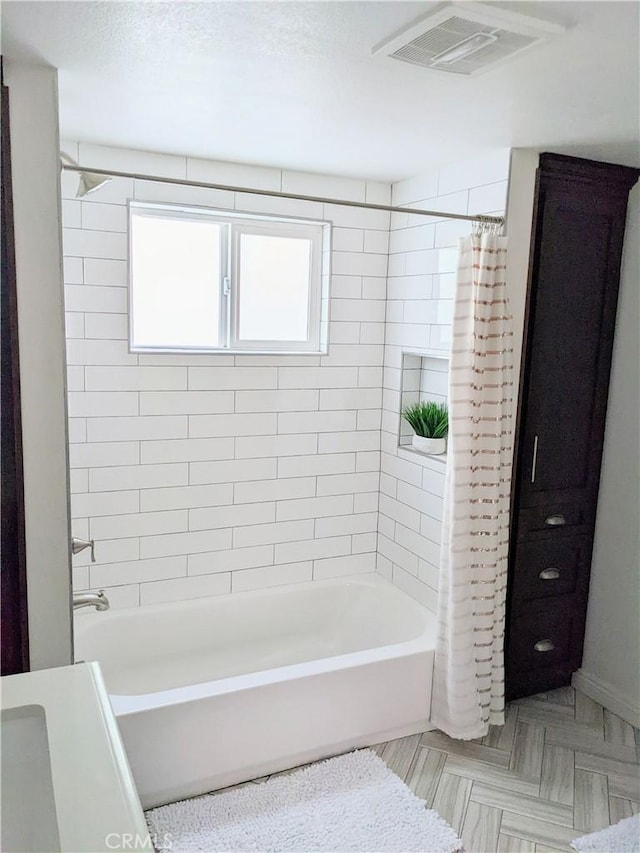 bathroom with shower / bath combo and visible vents