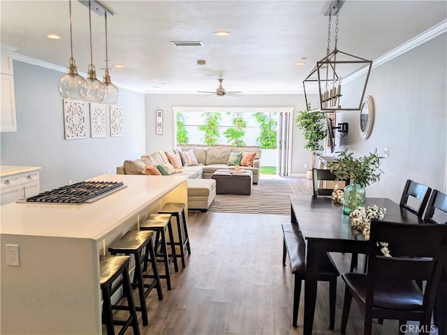 dining space featuring ceiling fan, ornamental molding, wood finished floors, and recessed lighting