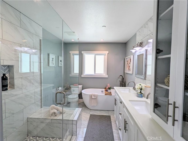 bathroom with a sink, double vanity, a freestanding tub, and a shower stall