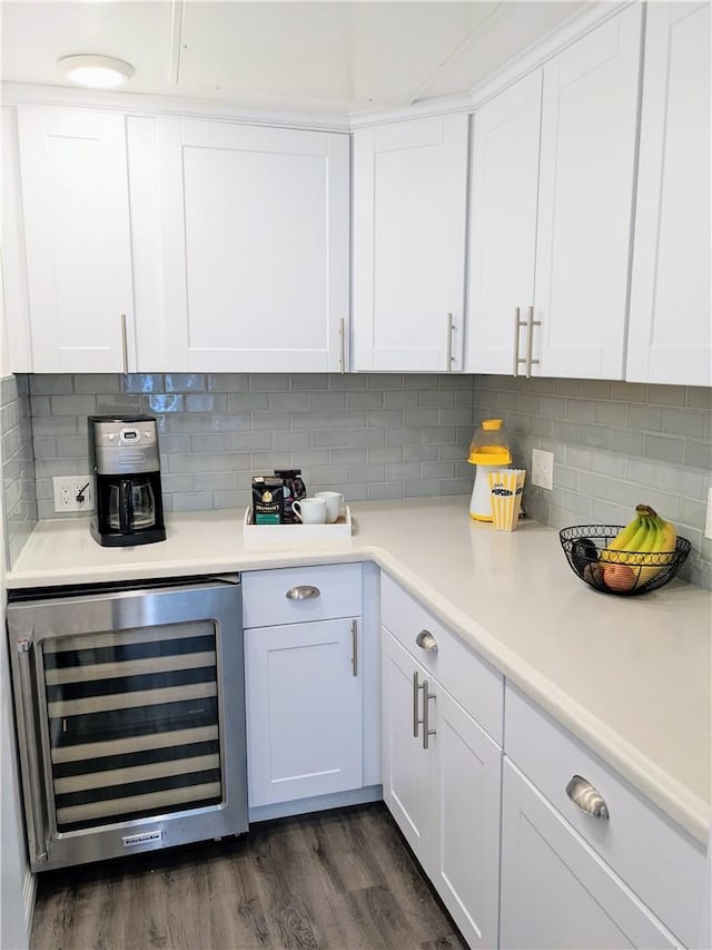 interior space with dark wood-type flooring, beverage cooler, white cabinets, and decorative backsplash