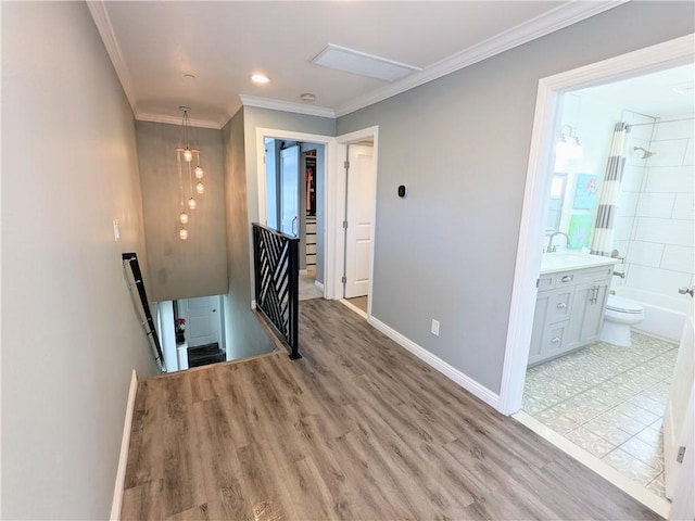 stairway featuring ornamental molding, baseboards, and wood finished floors