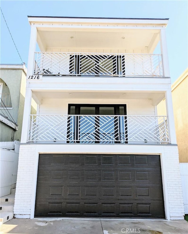 view of front of home featuring a garage, brick siding, and a balcony