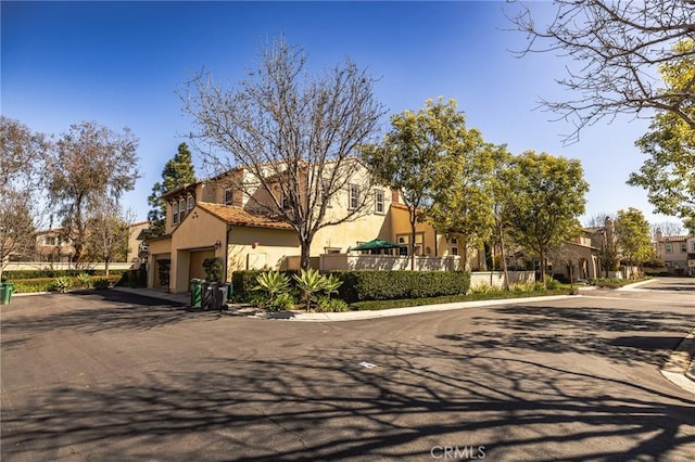 view of front of home featuring a garage, a residential view, and stucco siding