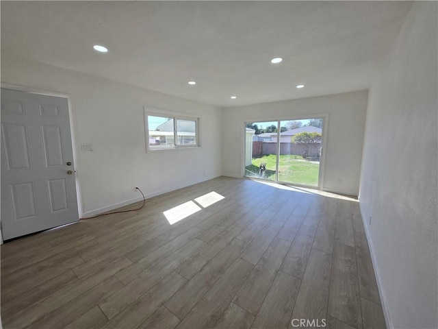 unfurnished room featuring baseboards, wood finished floors, and recessed lighting