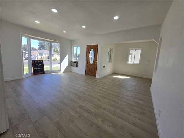 unfurnished living room featuring recessed lighting, baseboards, and wood finished floors