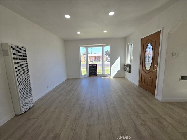 foyer entrance with recessed lighting, a heating unit, baseboards, and wood finished floors