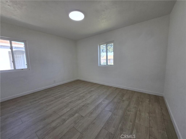 empty room featuring baseboards and wood finished floors