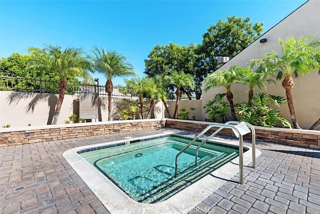 view of swimming pool featuring a patio area, a fenced backyard, and a hot tub