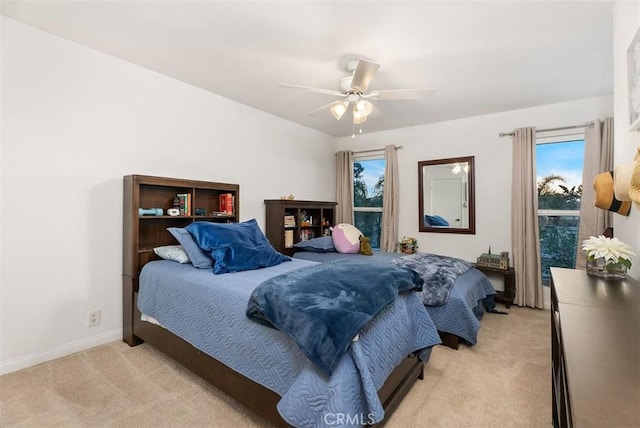 bedroom with light carpet, ceiling fan, and baseboards