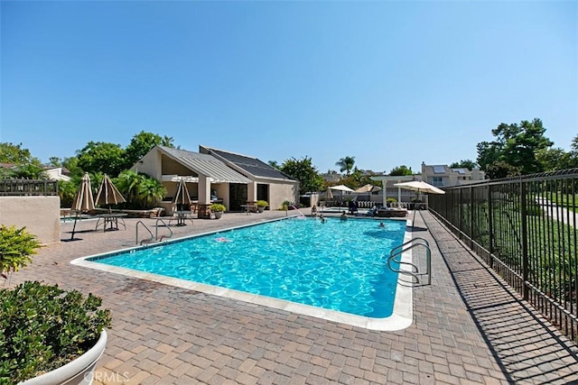 pool with a patio and fence