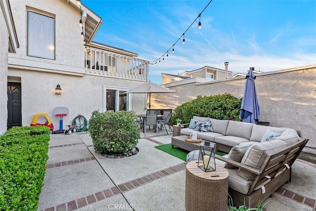 view of patio with a balcony, outdoor dining area, and an outdoor living space