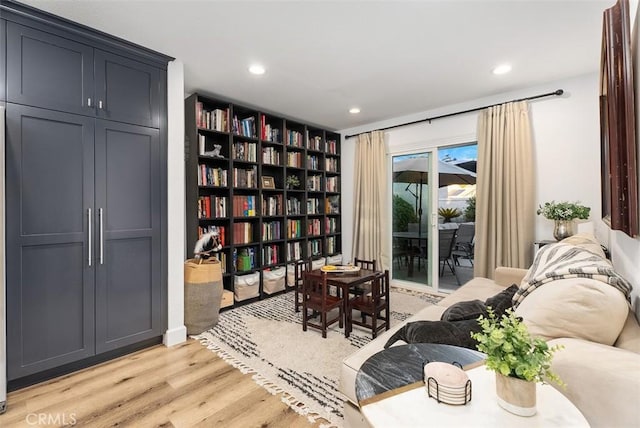 living area with light wood-type flooring and recessed lighting