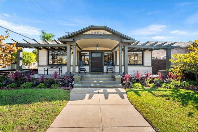 property entrance with a porch, a pergola, and a yard