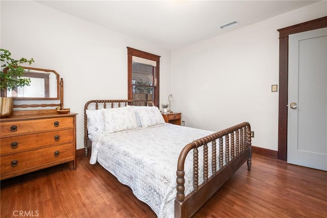 bedroom featuring baseboards, visible vents, and wood finished floors