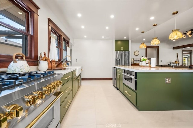 kitchen with stainless steel appliances, green cabinetry, and light countertops