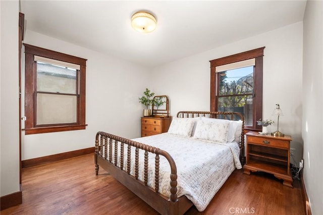 bedroom with baseboards and wood finished floors