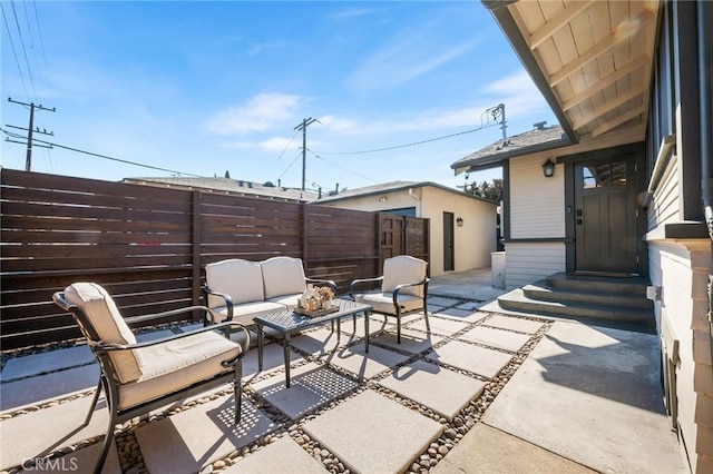 view of patio / terrace featuring entry steps, fence, and an outdoor living space