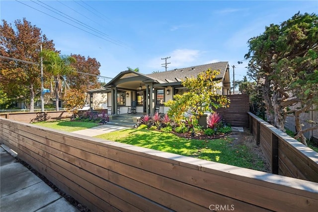 view of front of house featuring fence and a front lawn